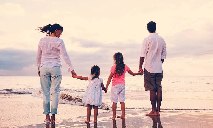 Parents with two young children walking outdoors together
